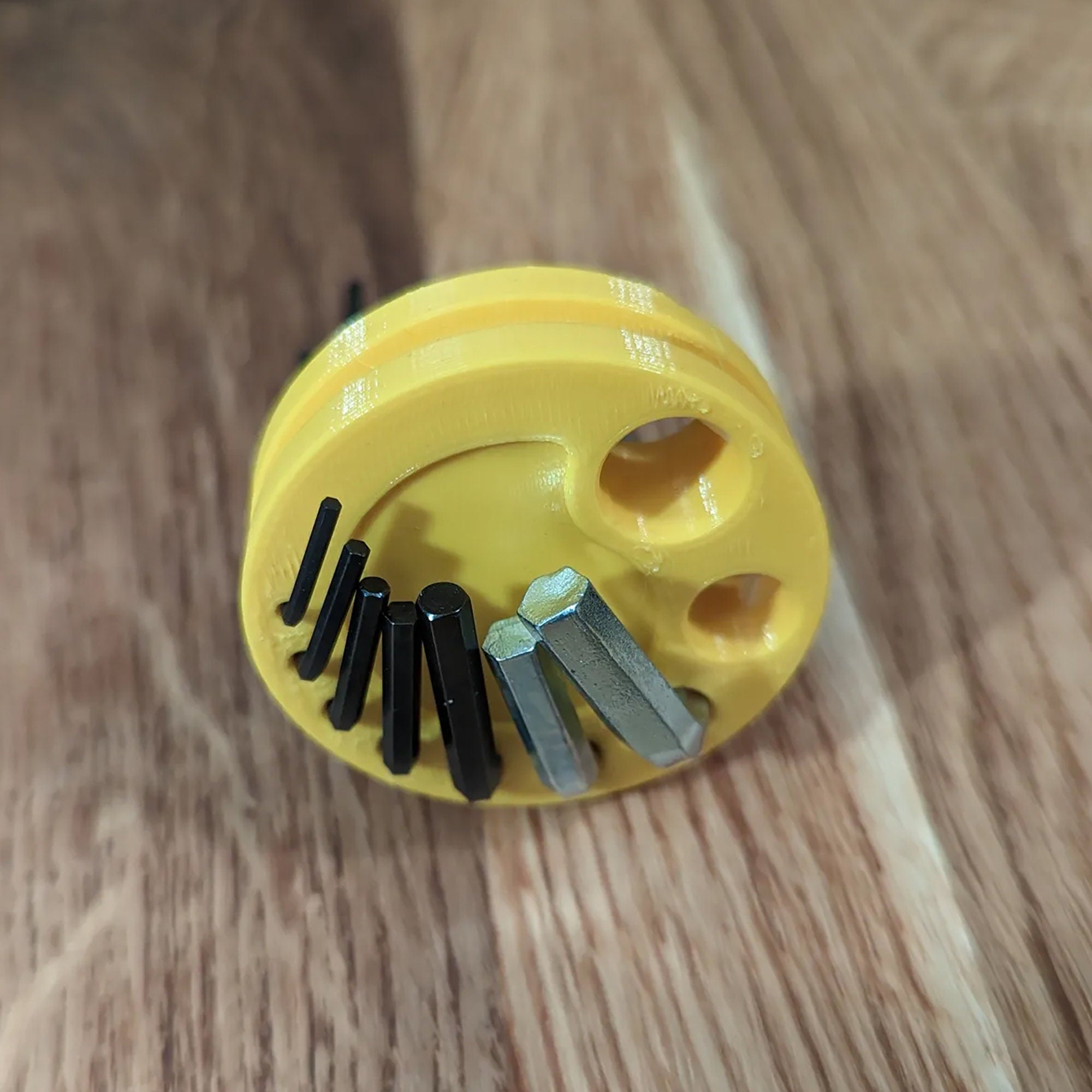 a yellow brush with a bunch of screws in it