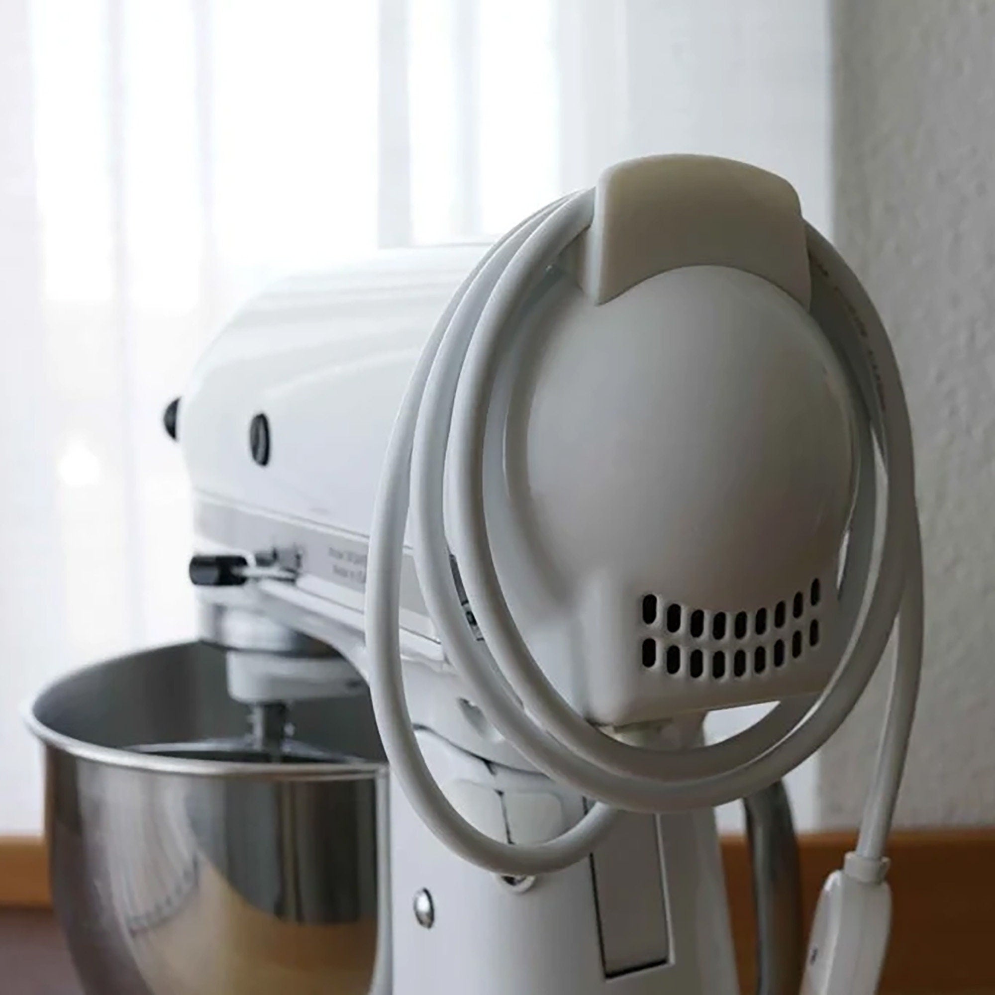 a white mixer sitting on top of a wooden table