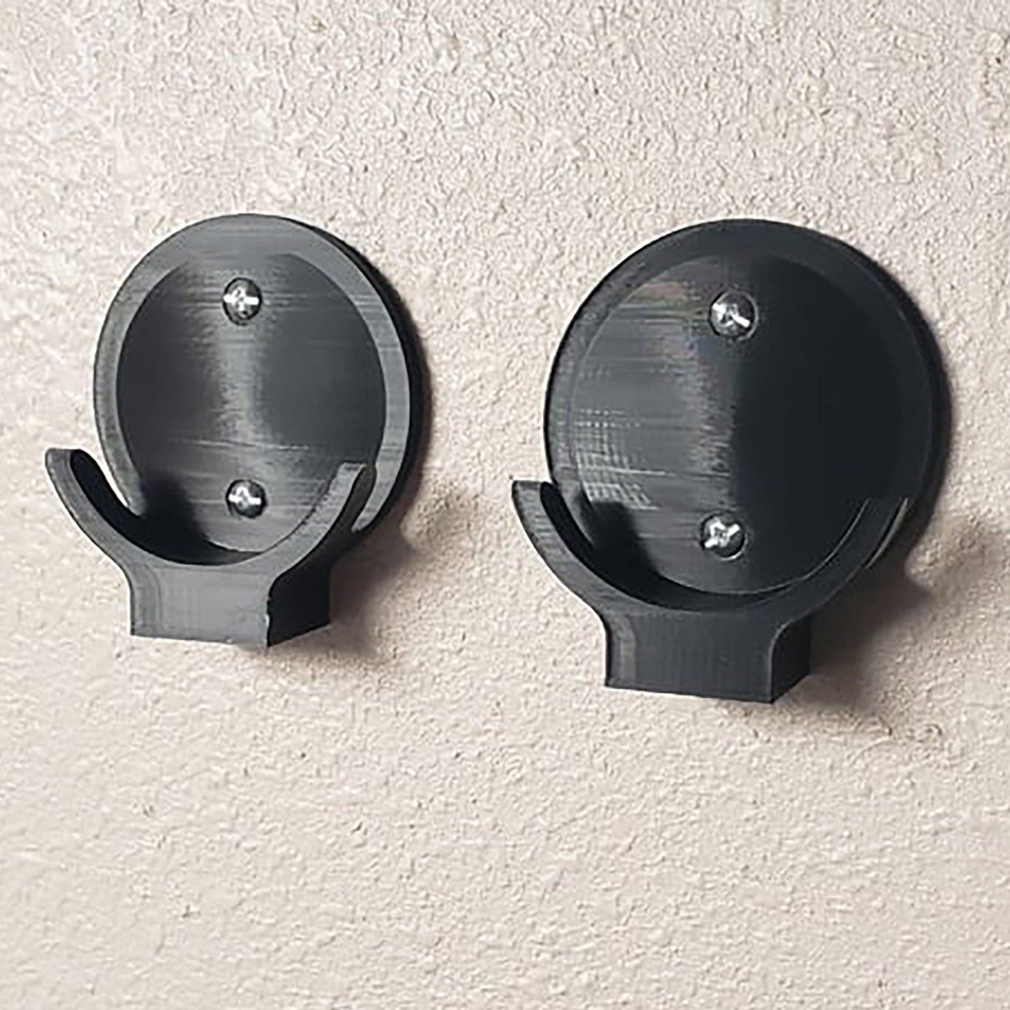 a pair of black metal hooks on a wall