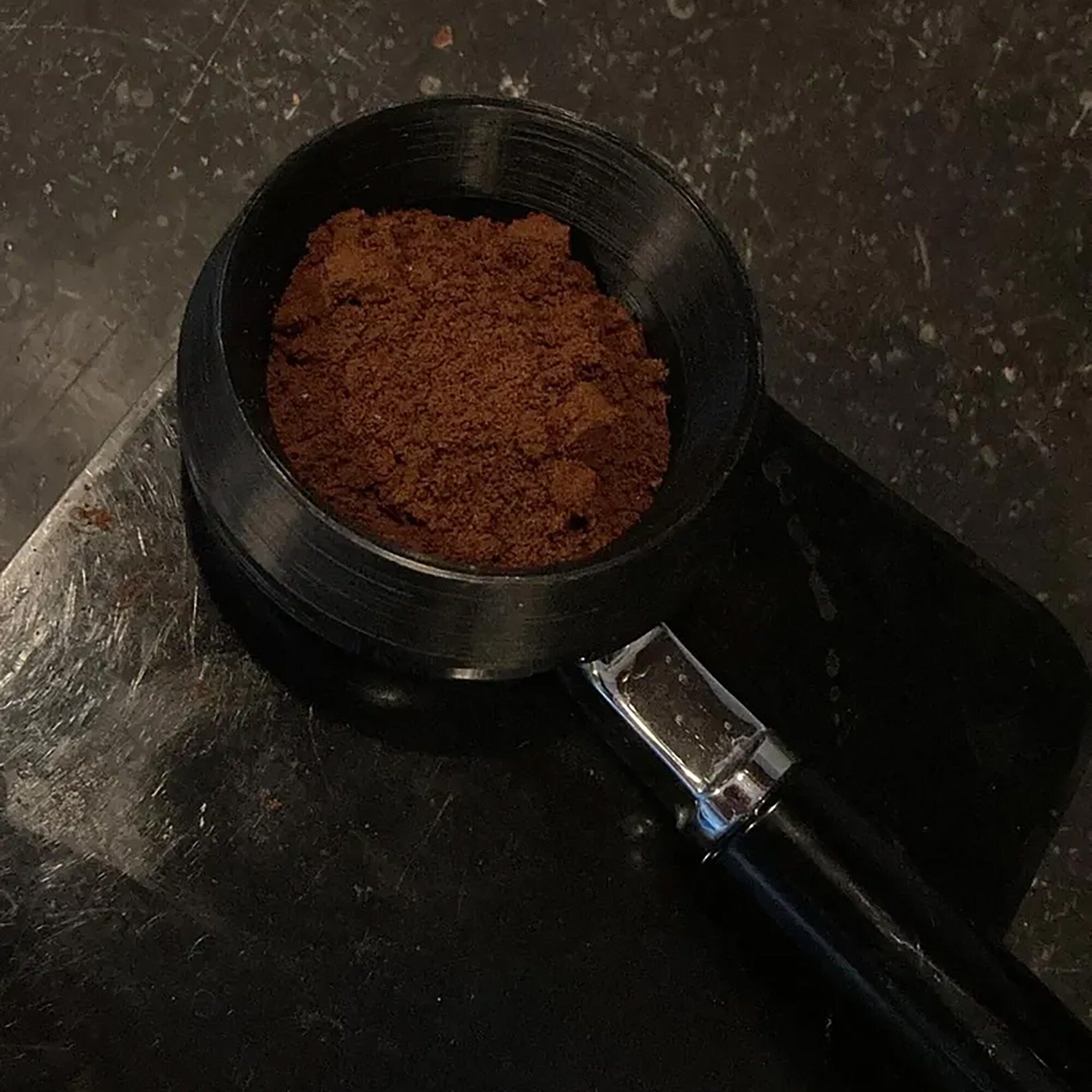 a metal bowl filled with brown powder next to a knife