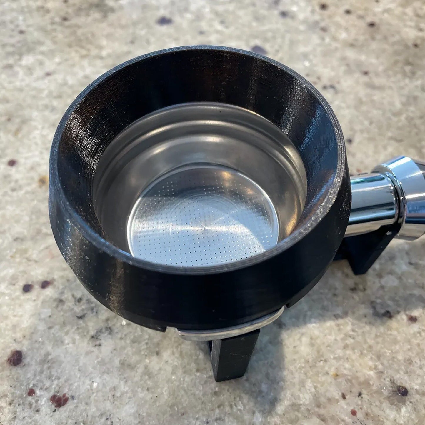 a stainless steel strainer on a marble surface