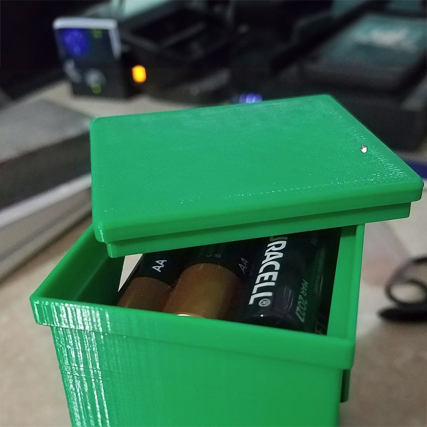 a green box with two batteries inside of it