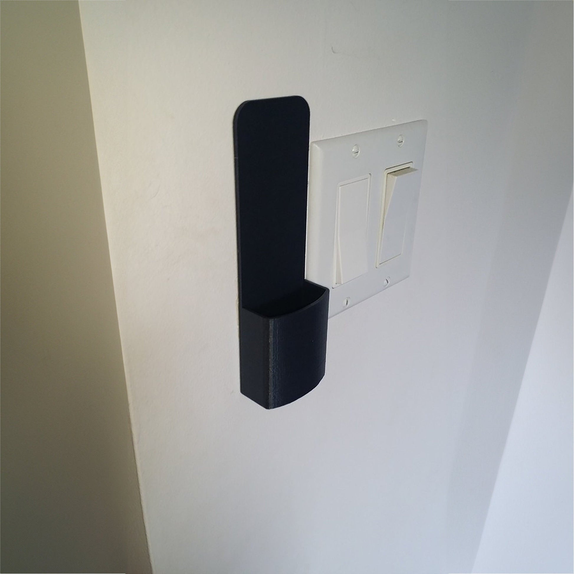 a white wall with a black object on it