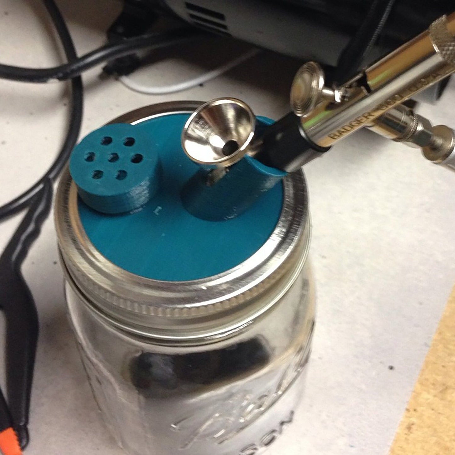 a mason jar with a blue lid and a pair of scissors sticking out of it