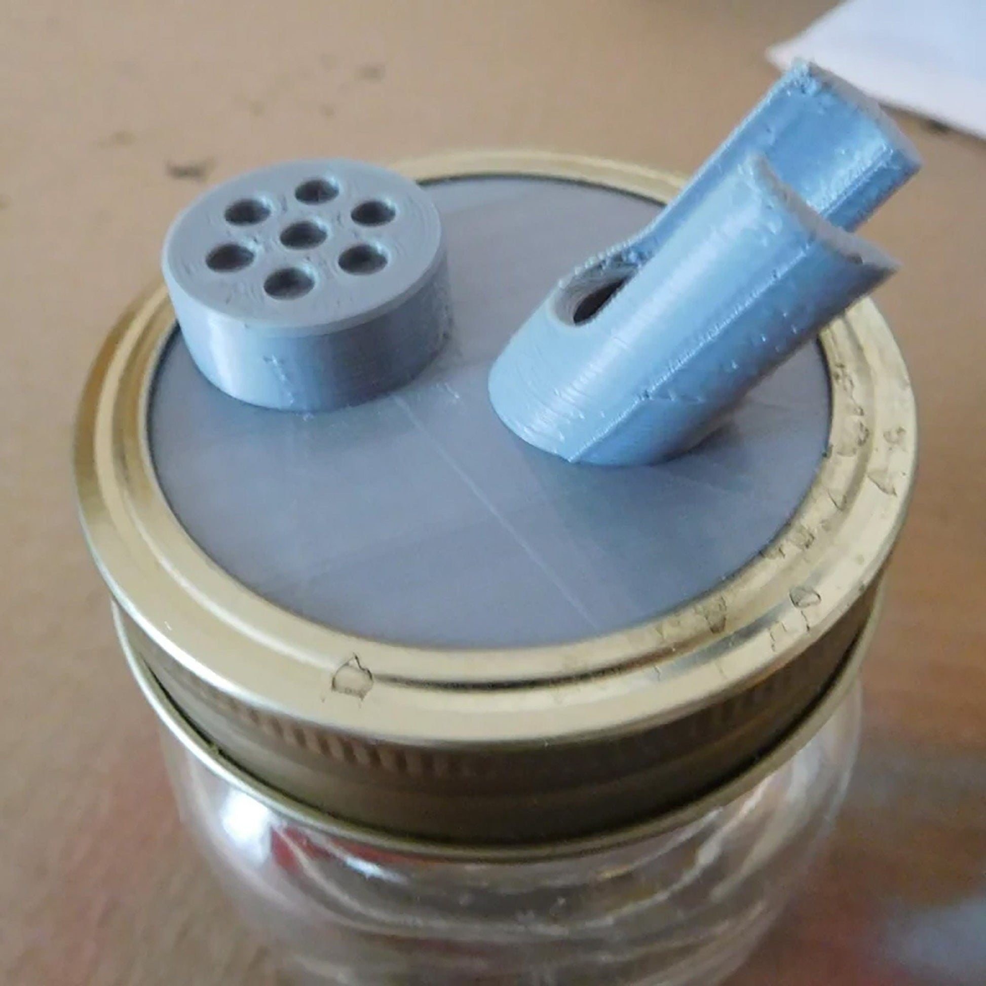 a glass jar with a metal lid and a blue object on top of it