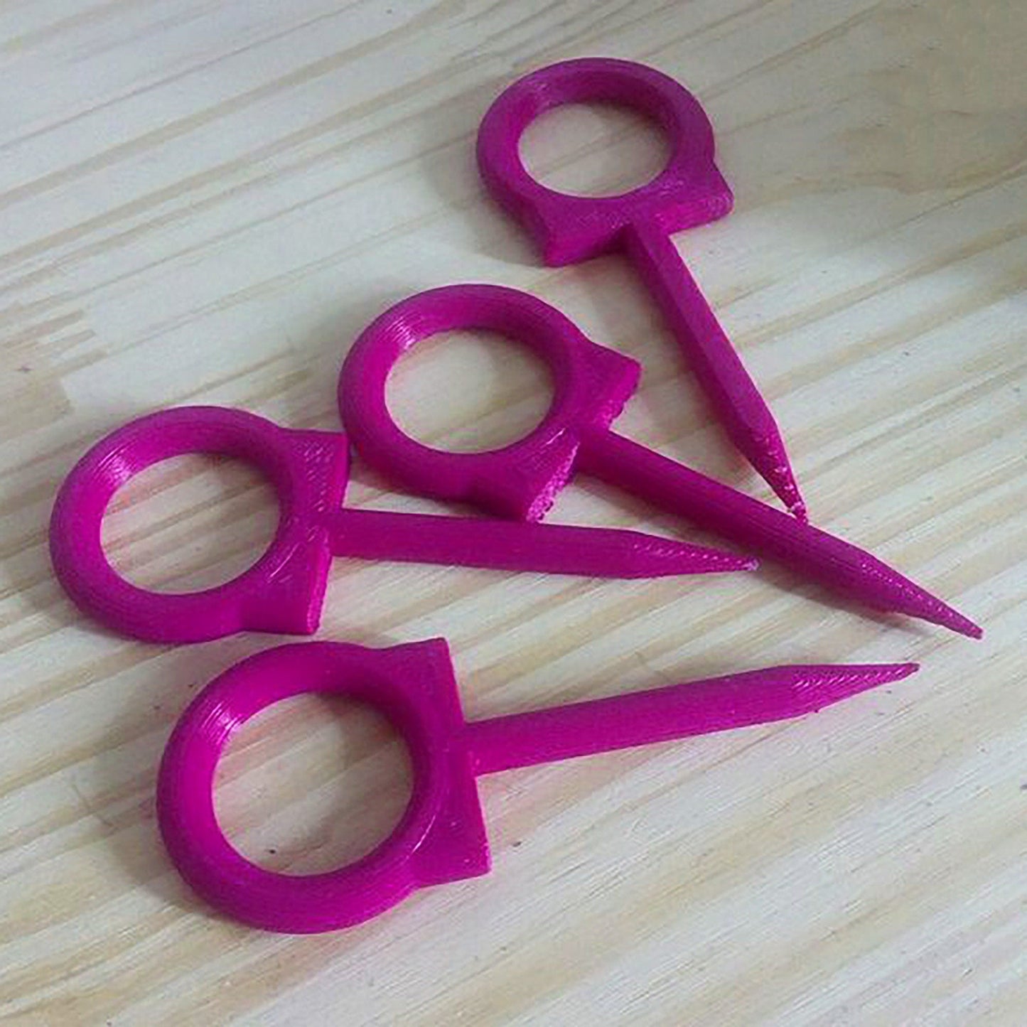 a group of pink scissors sitting on top of a wooden table