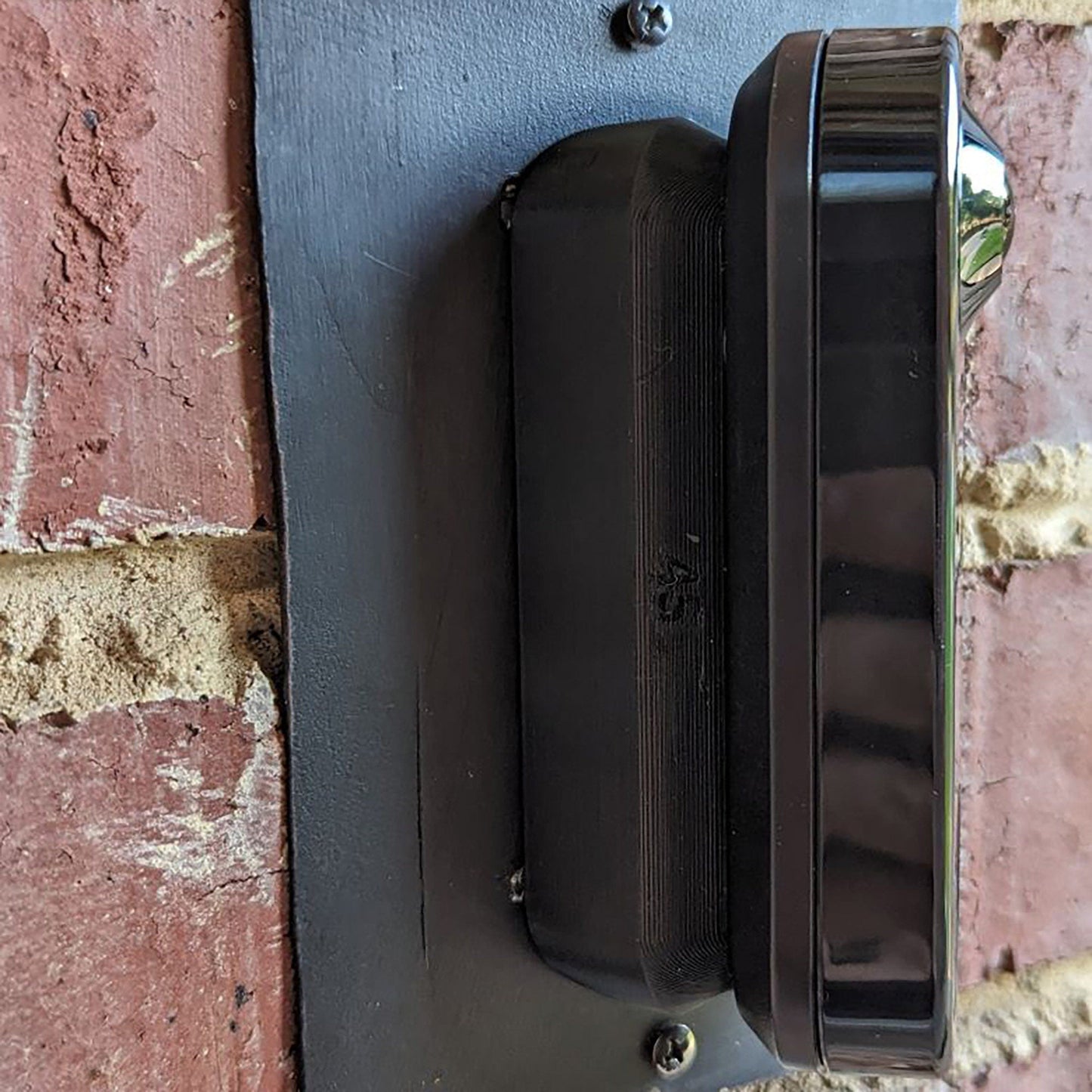 a black door handle on a brick wall