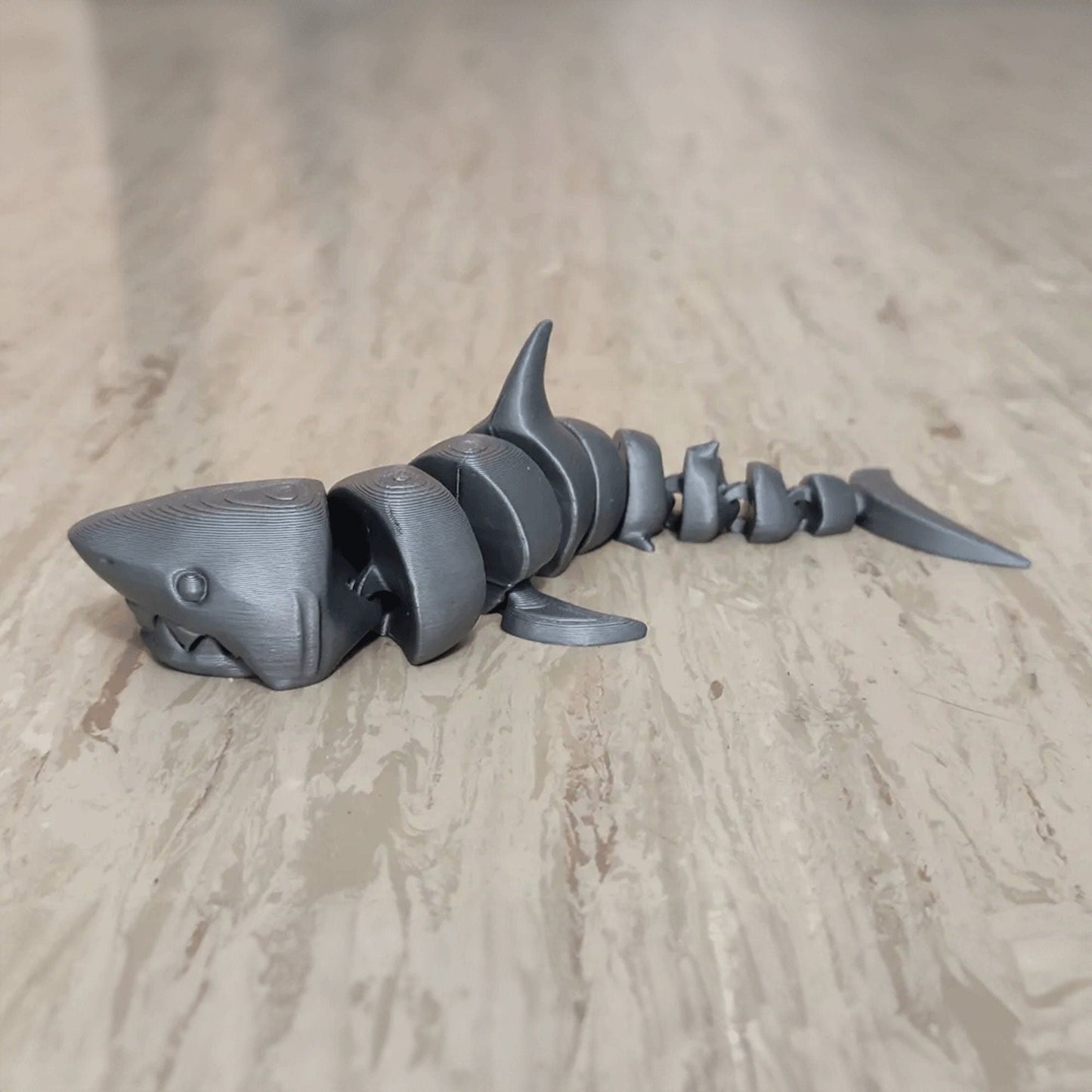 a toy shark laying on top of a wooden floor