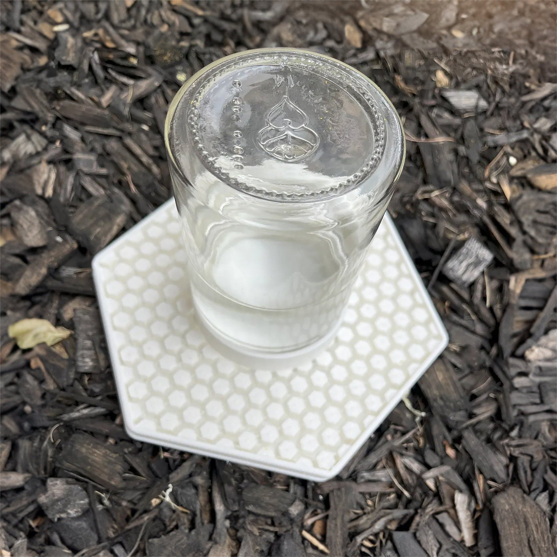 a glass of water sitting on top of a white coaster