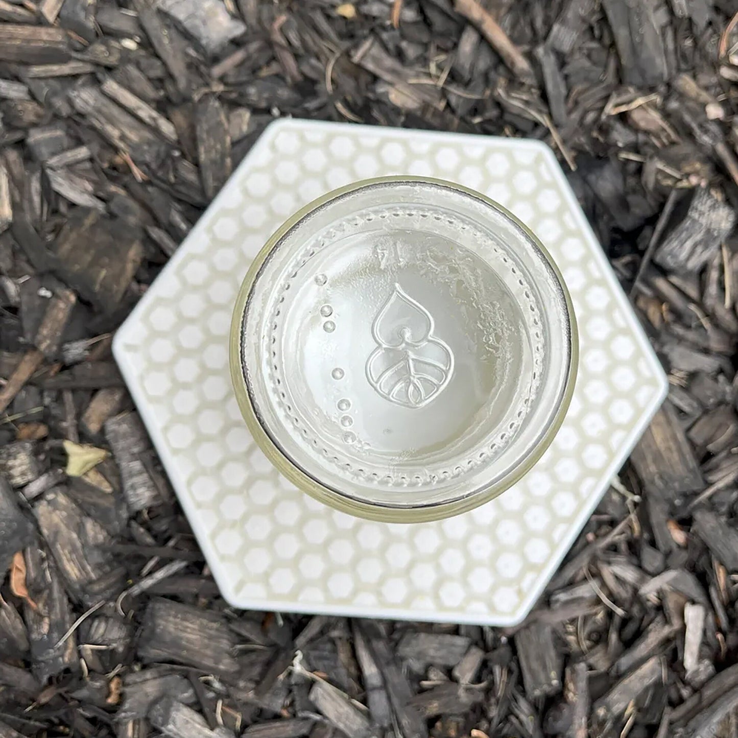 a glass cup sitting on top of a pile of wood chips