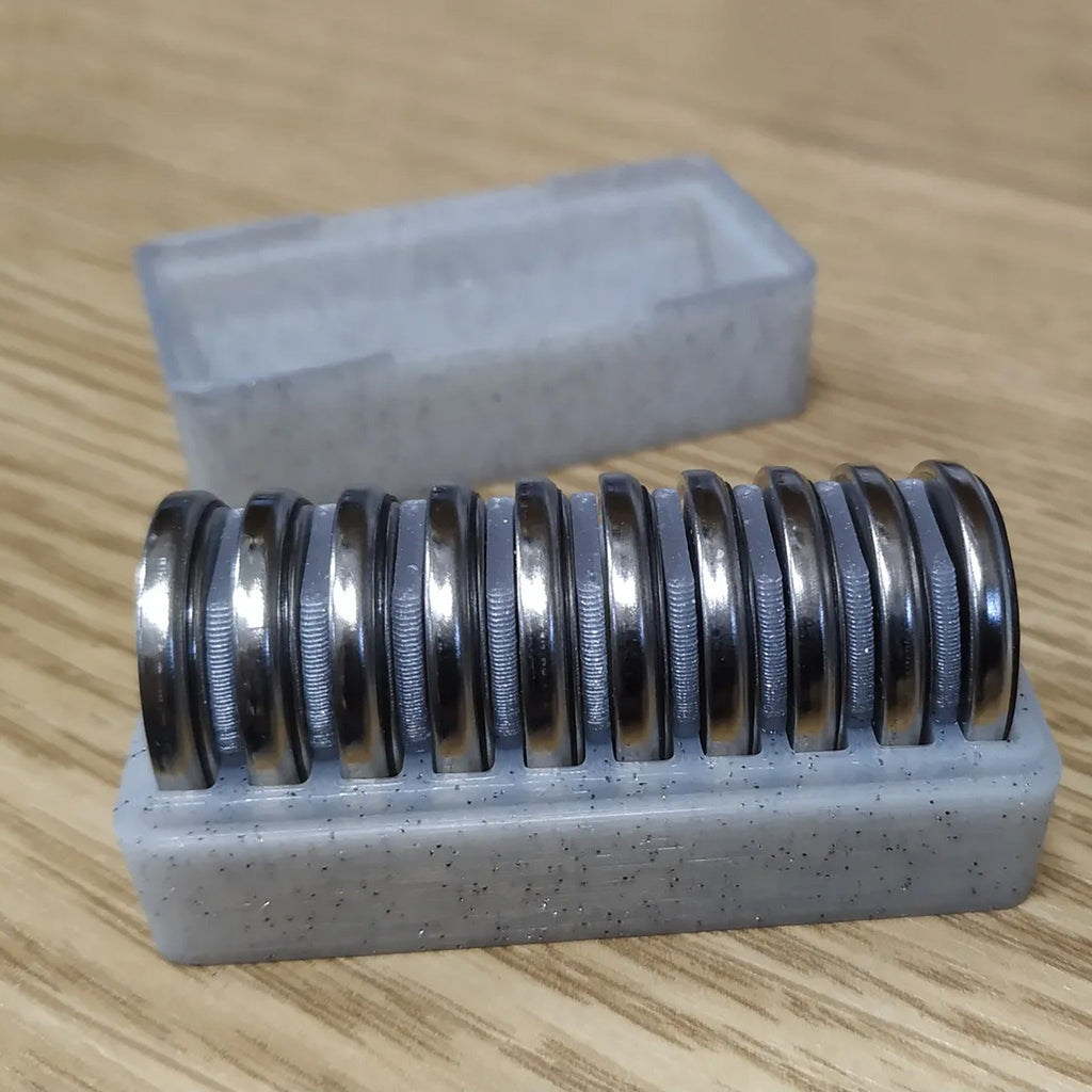 CR2032 coin cell storage box with a slotted tray holding batteries on edge, view 2