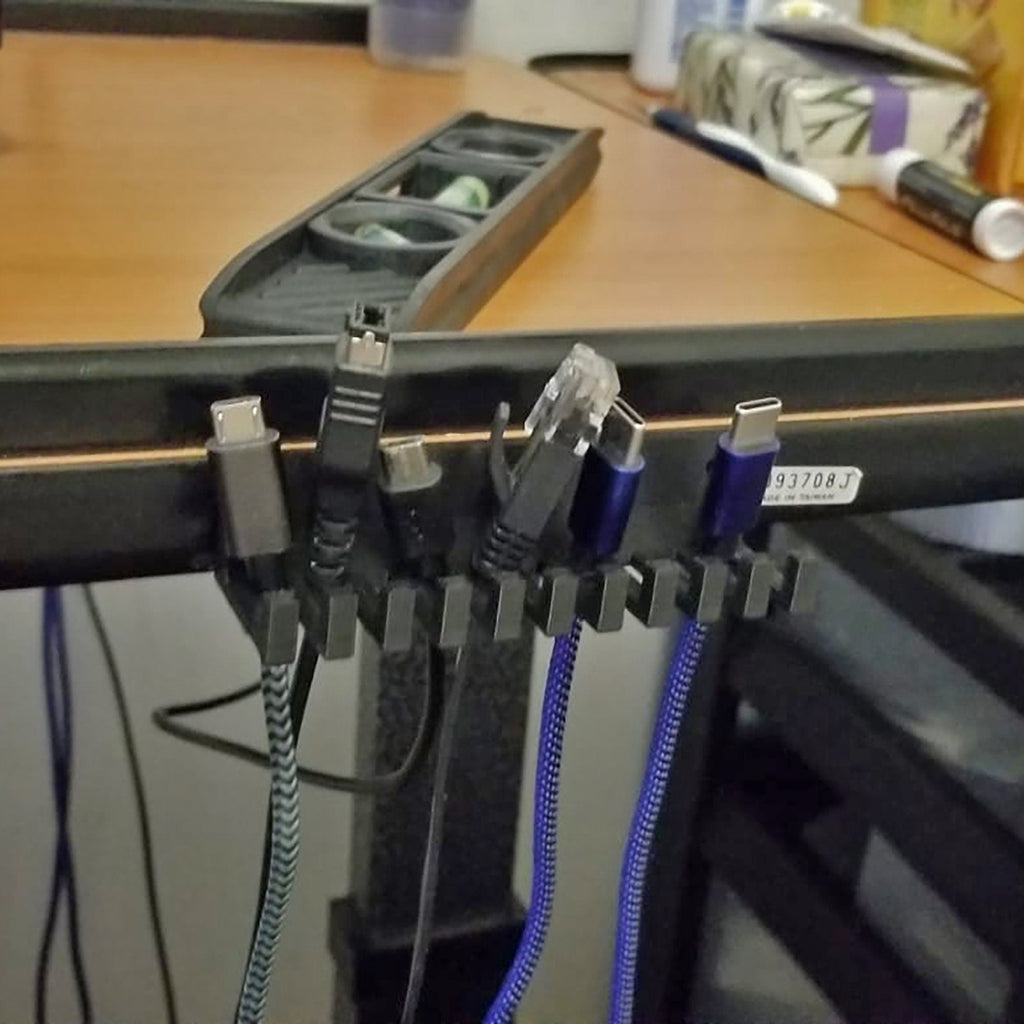 Slotted cable holder organizer docking charging cable ends on a desk edge, view 5