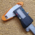 a calculator with a tape measure attached to it