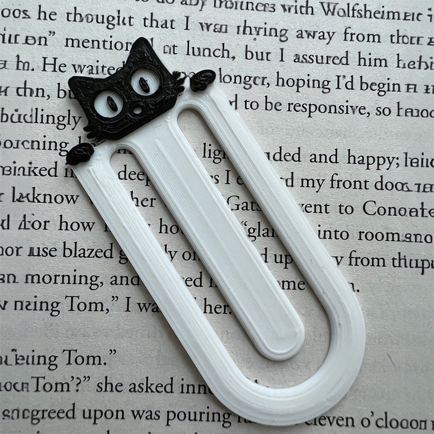 a bookmark with a black cat on top of it