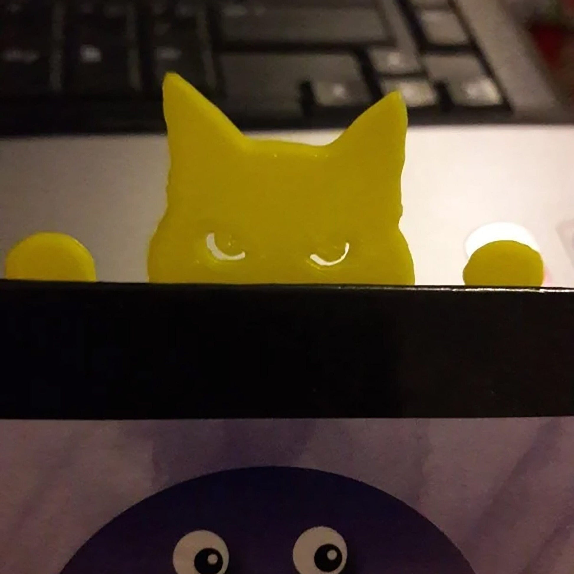 a yellow cat sitting on top of a laptop computer