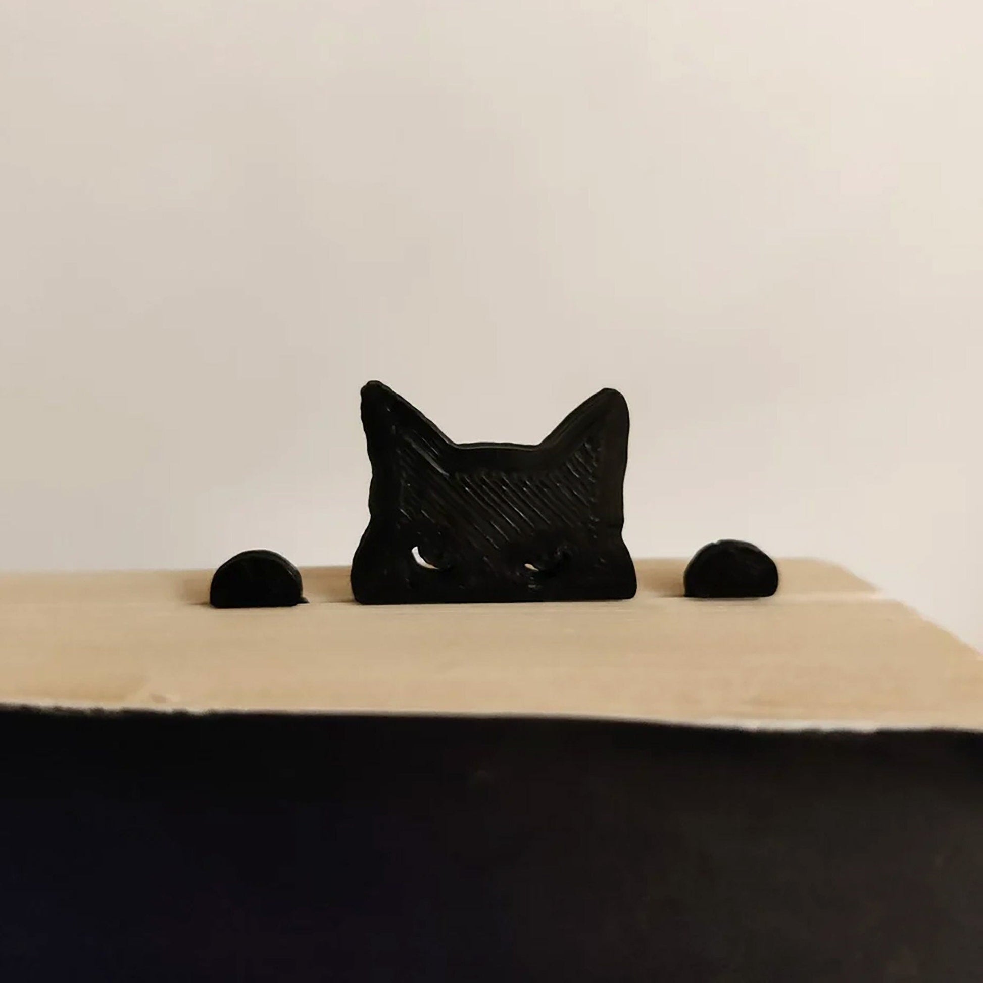 a black cat figurine sitting on top of a table