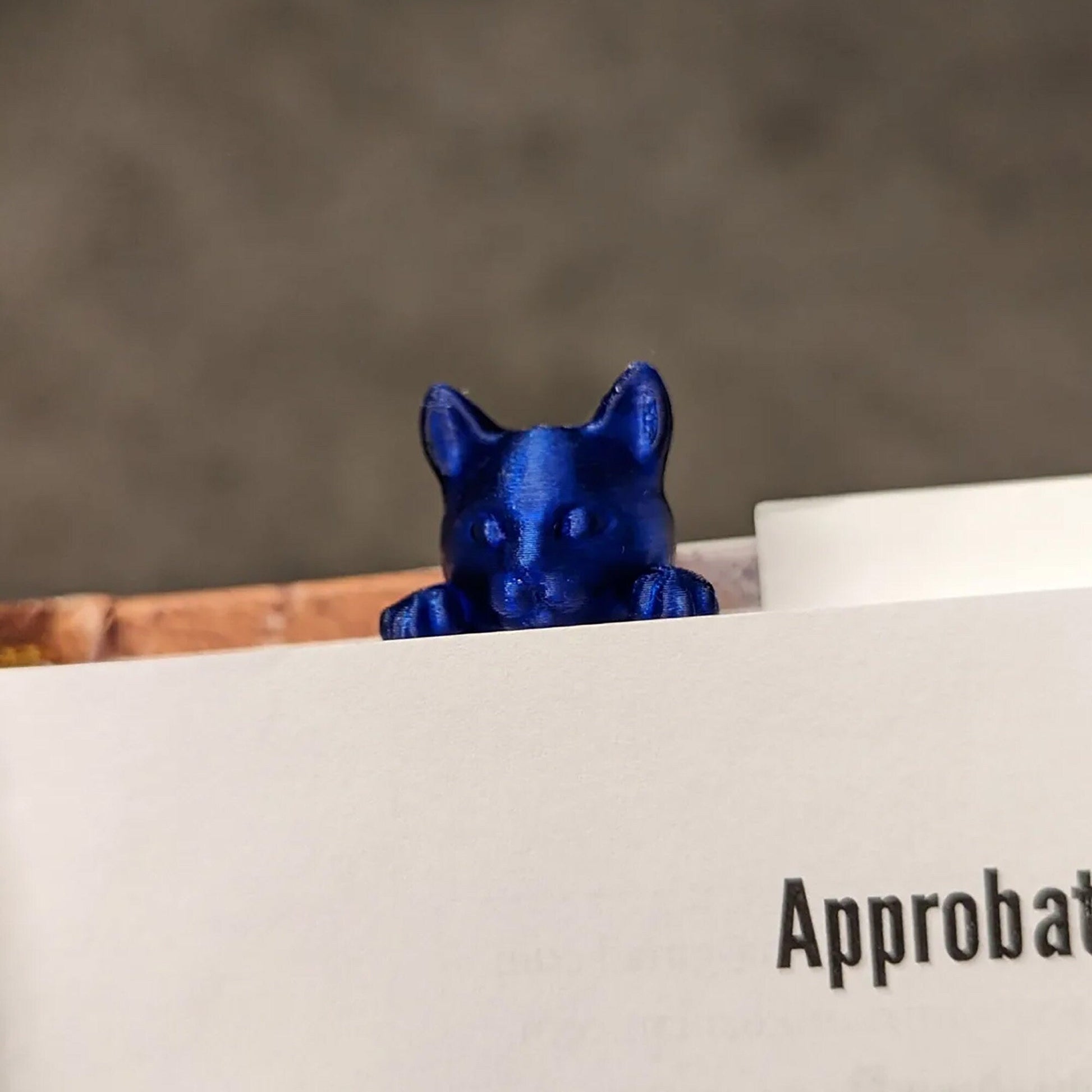 a blue cat figurine sitting on top of a piece of paper