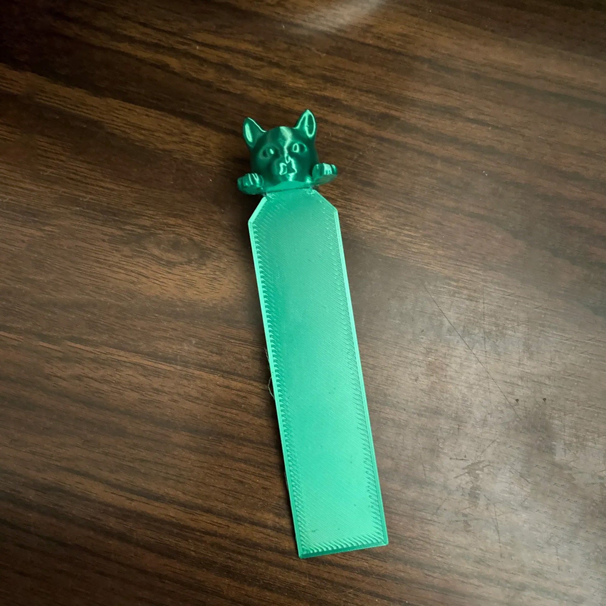 a piece of green plastic sitting on top of a wooden table