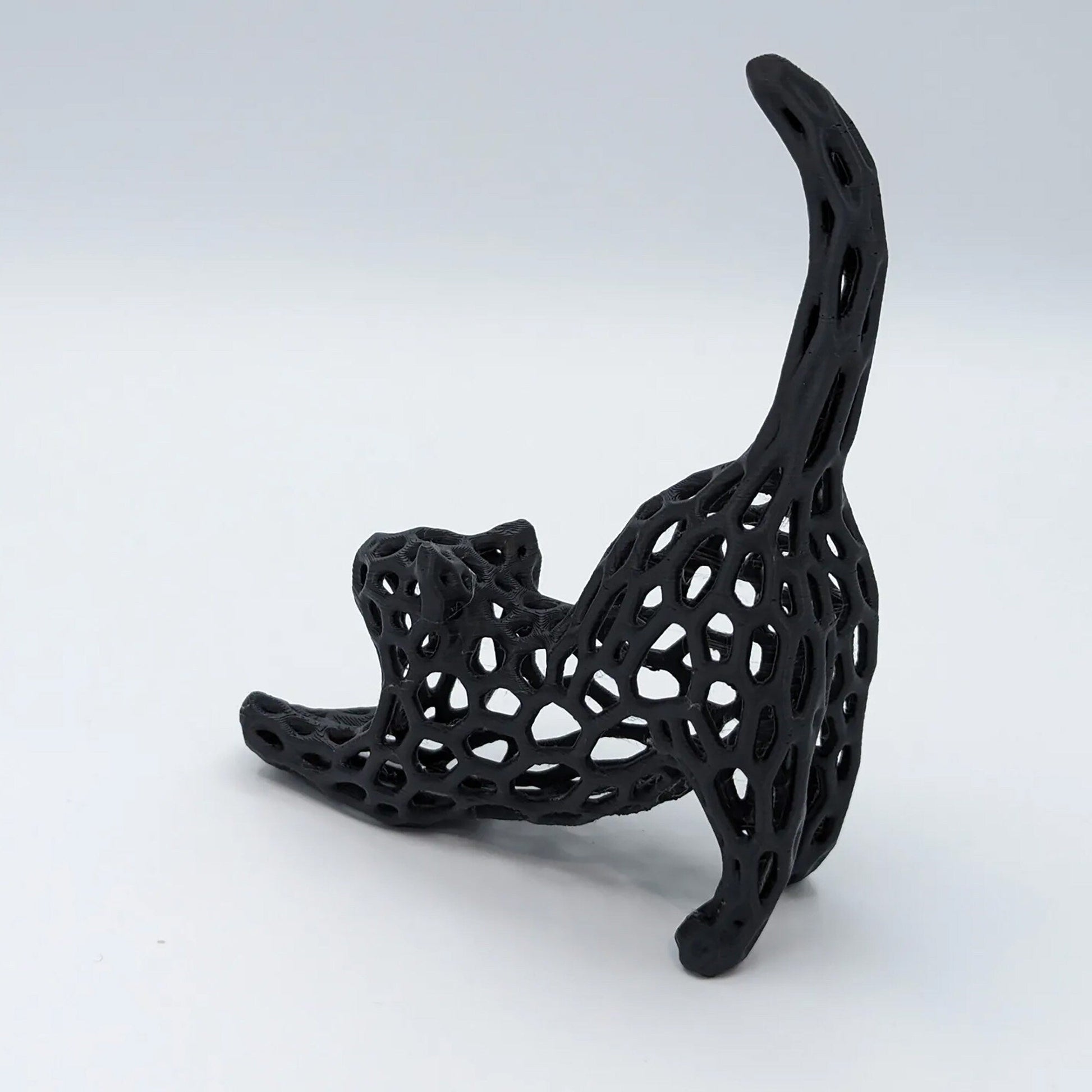 a black sculpture of a cat on a white background