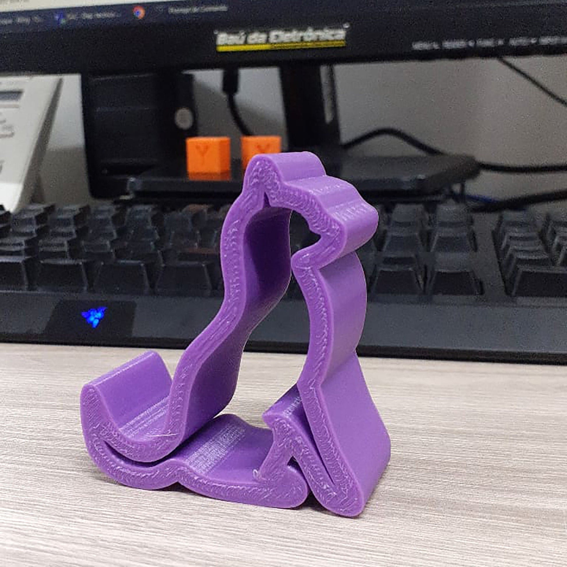 a purple object sitting on top of a desk next to a keyboard