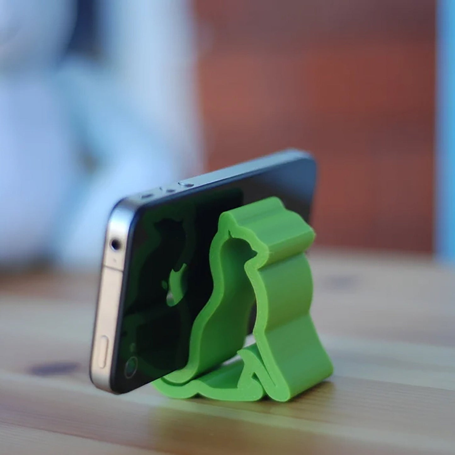 a cell phone holder sitting on top of a wooden table