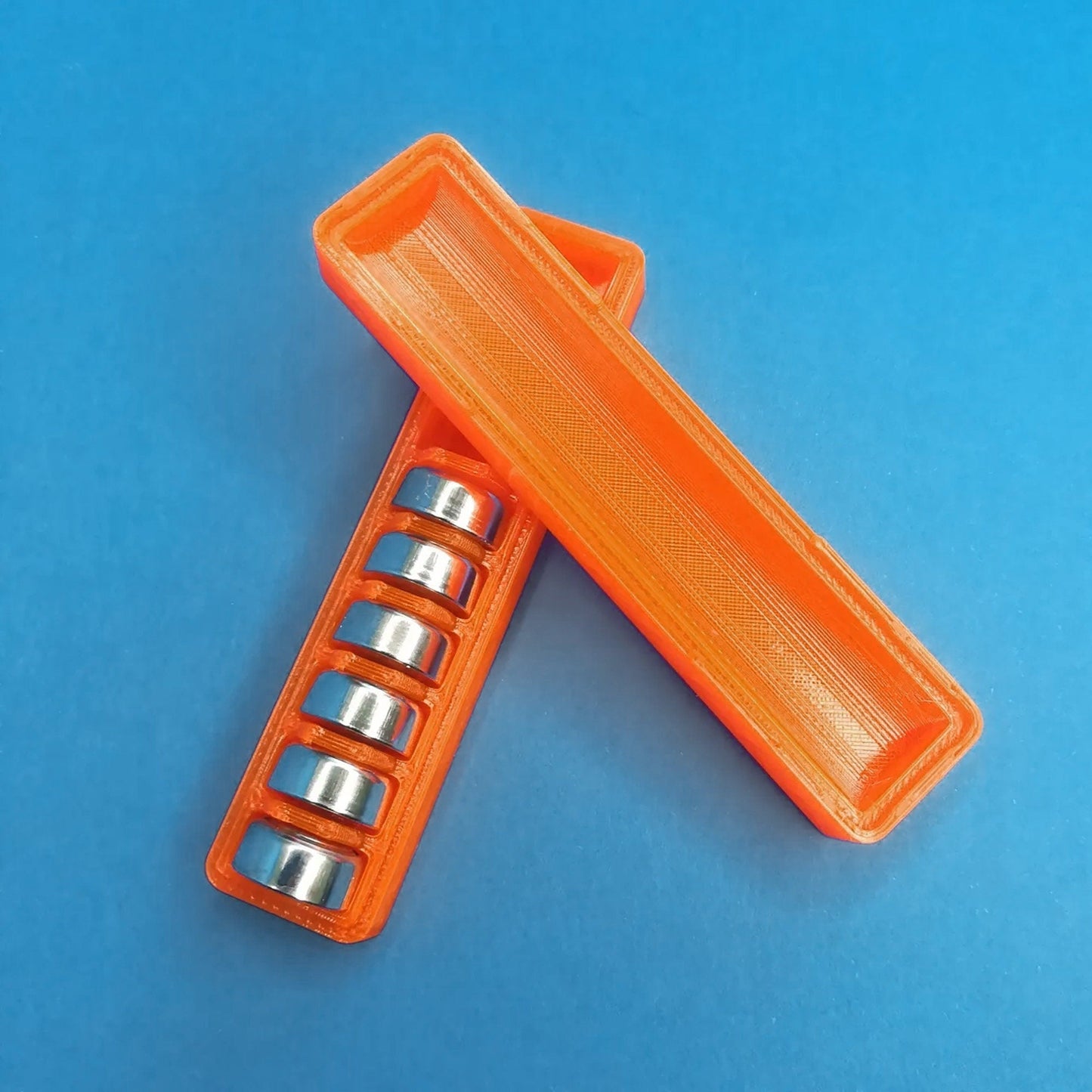 a couple of orange pill holders sitting on top of a blue surface