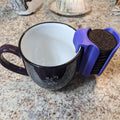 Cookie dunking clip caddy holding sandwich cookies on the rim of a mug
