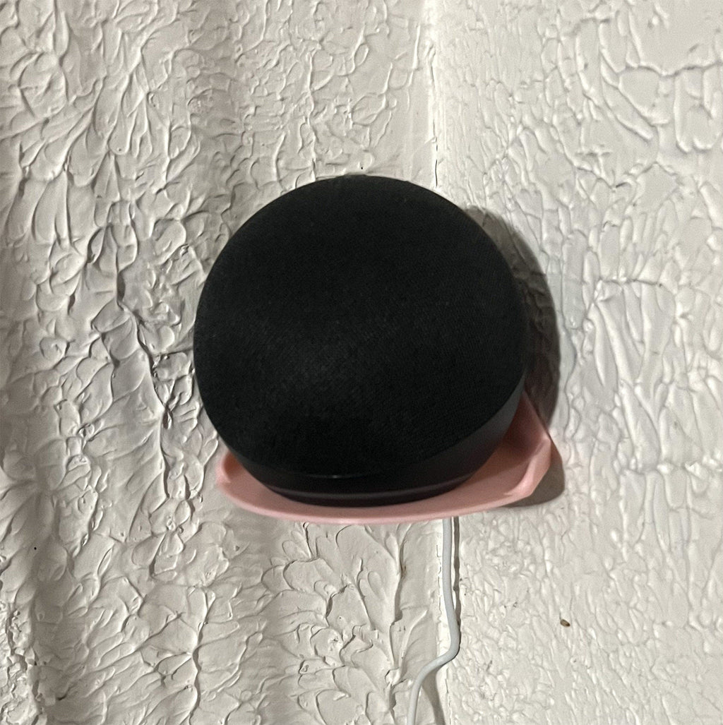 Wall mount cradle holding a spherical Echo Dot smart speaker