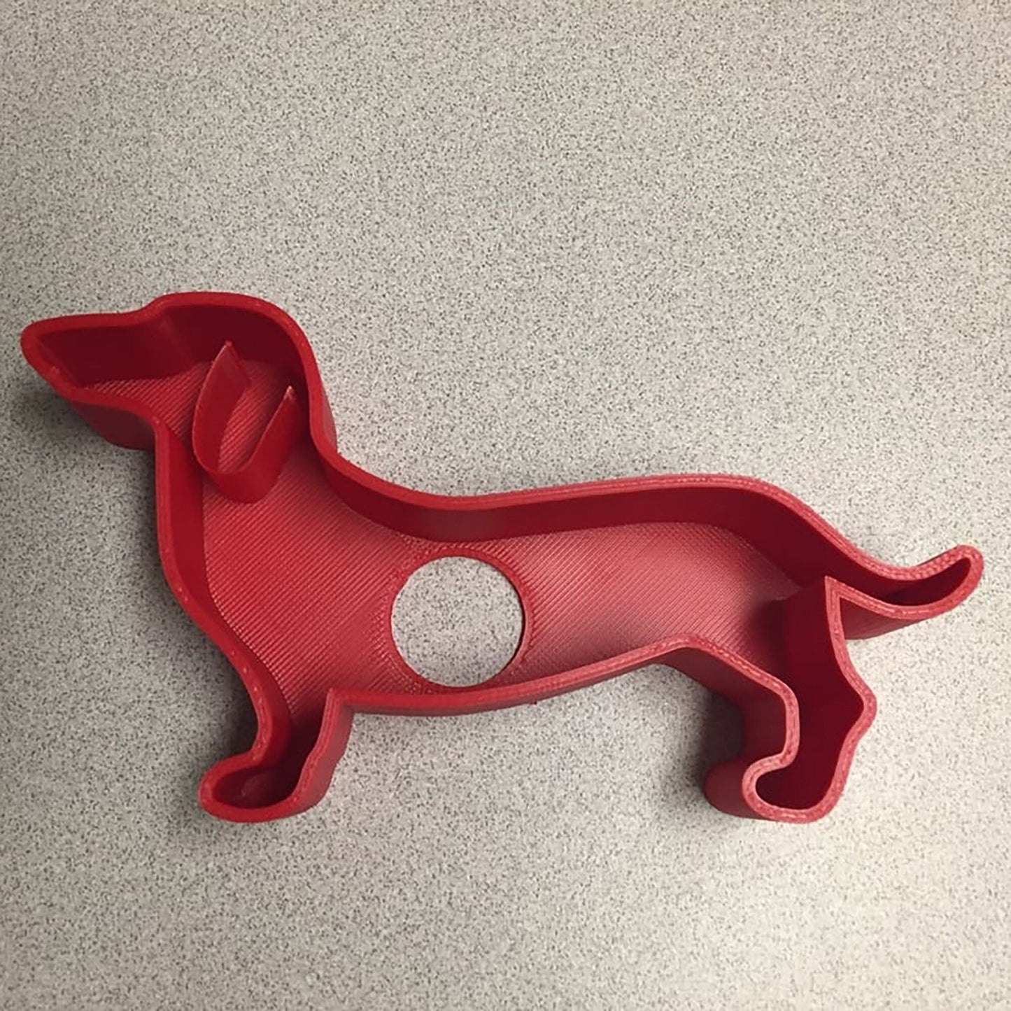 a red cookie cutter shaped like a dog