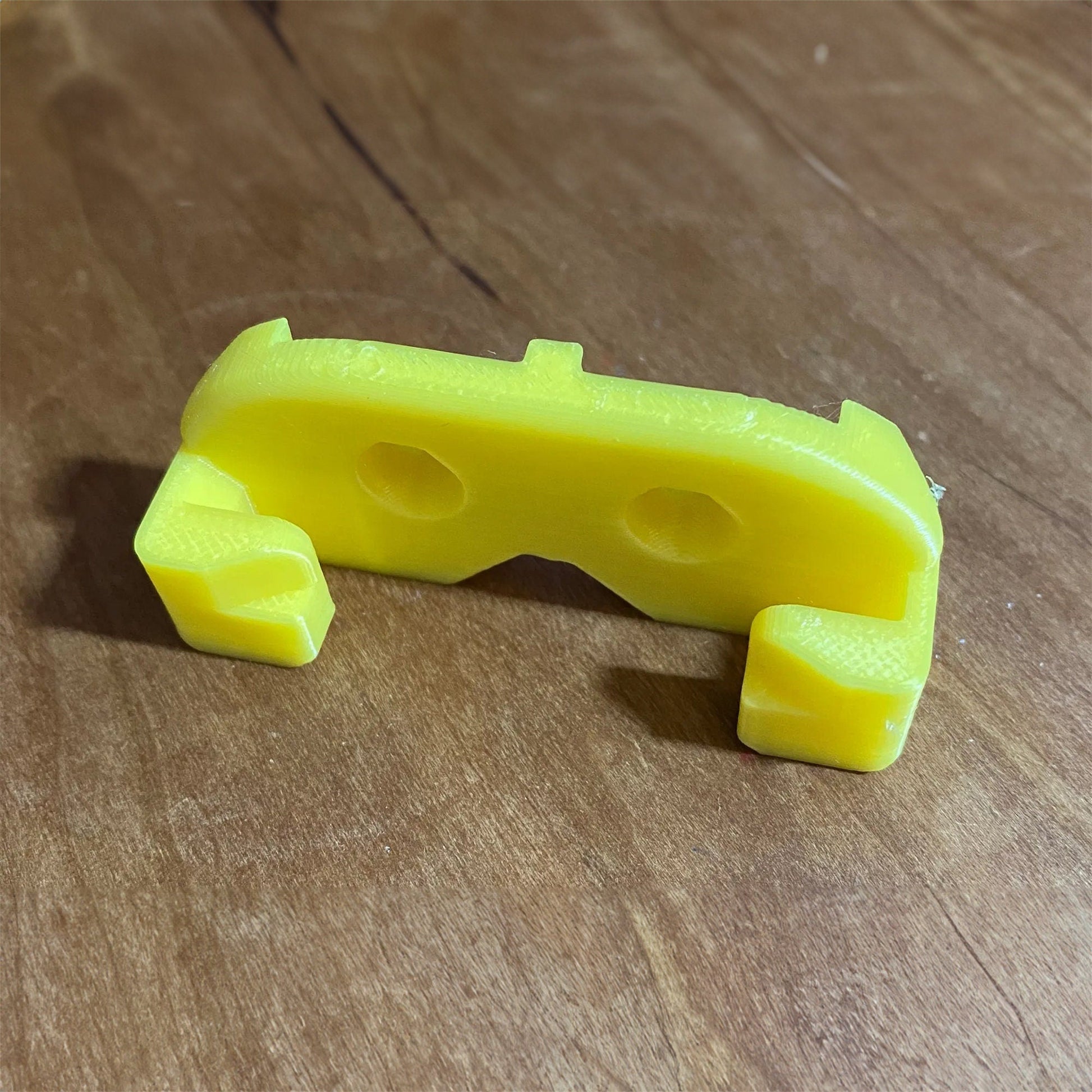 a yellow plastic object sitting on top of a wooden table