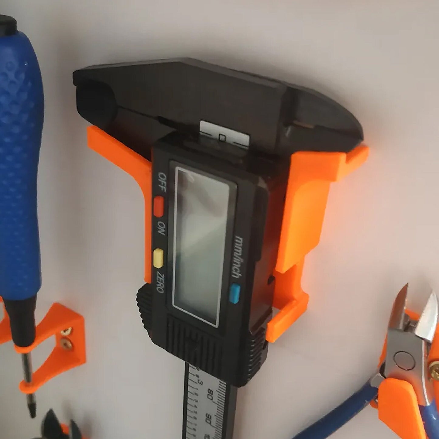 an orange and black meter and a pair of pliers