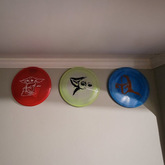 three frisbees are hanging on a wall