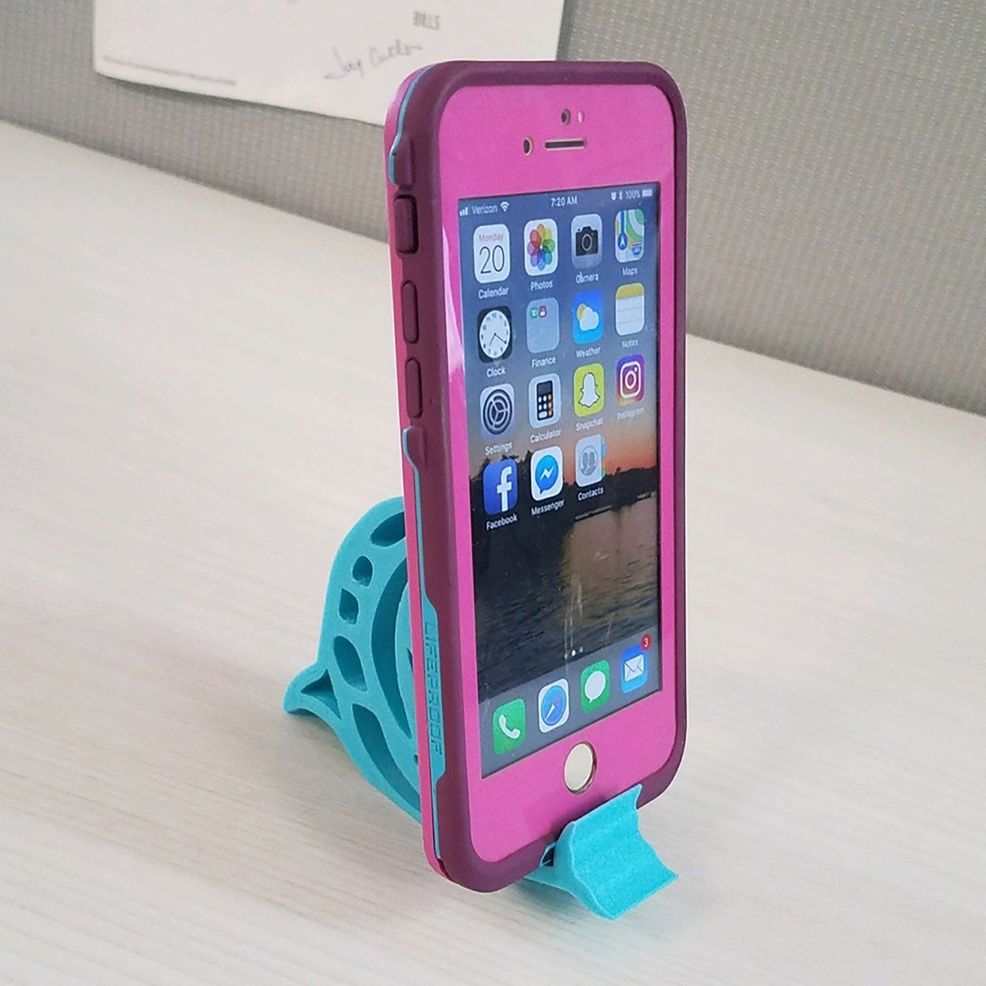 a pink and blue cell phone sitting on top of a table