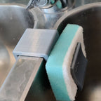 Sponge holder over a double kitchen sink divider holding two sponges, view 3