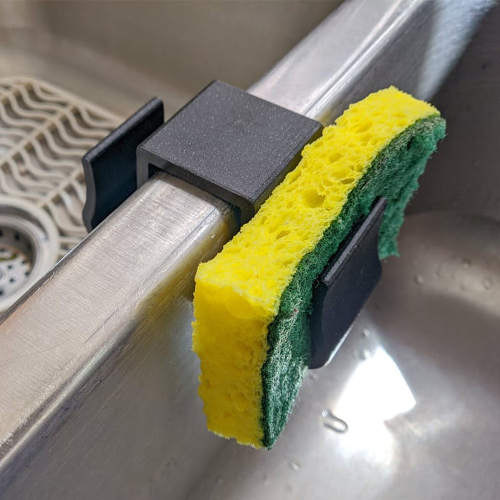 Sponge holder over a double kitchen sink divider holding two sponges