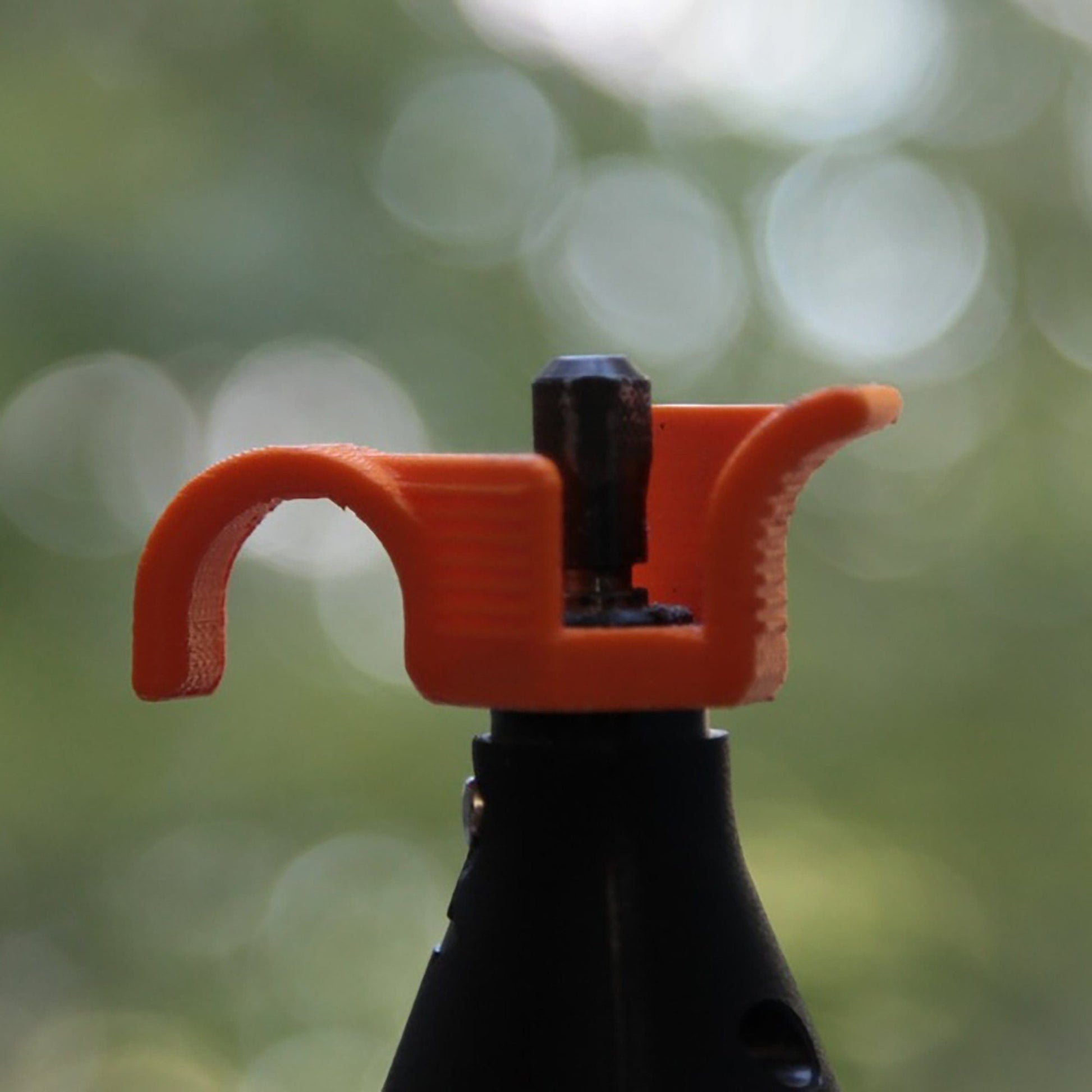 a close up of a black bottle with an orange handle