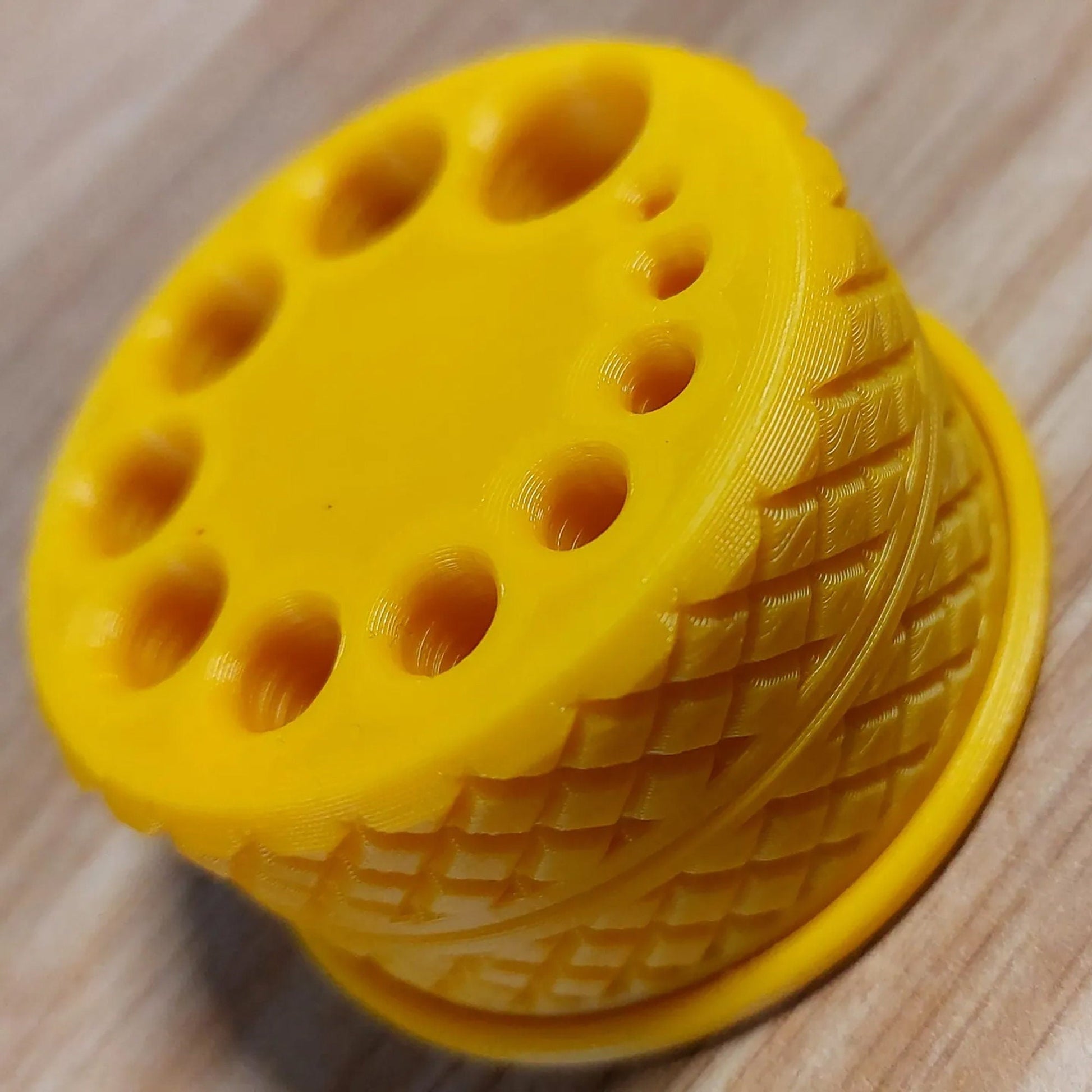 a close up of a yellow object on a wooden surface