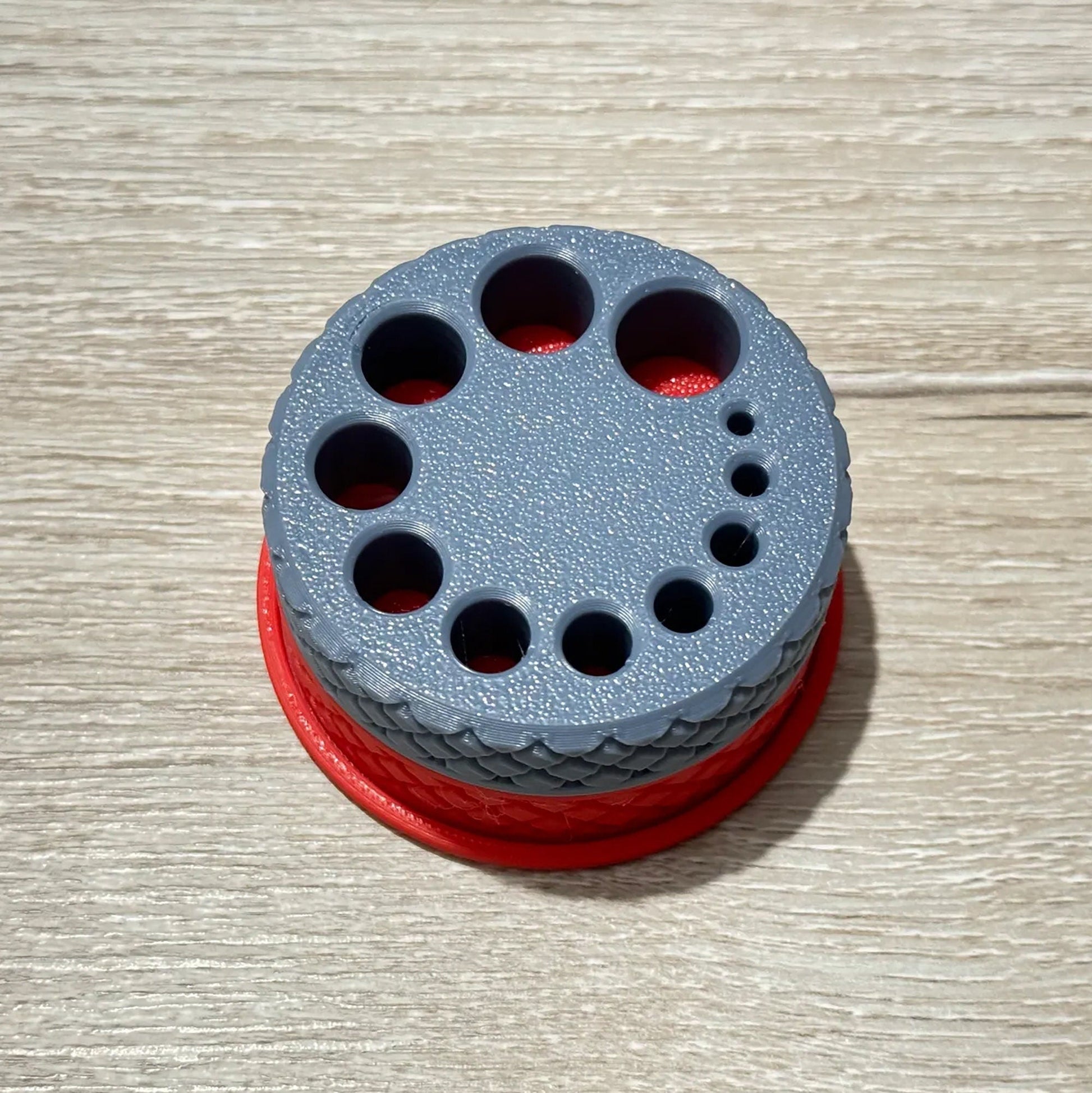 a gray and red object sitting on top of a wooden table