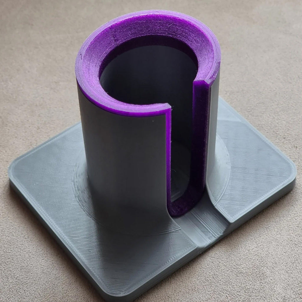 Hair tool stand holding a Dyson Airwrap upright with side cable slot and square base, view 2