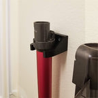 Wall mount wand holder storing a Dyson stick vacuum extension tube upright, view 2