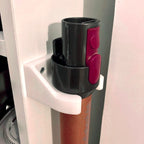 Wall mount wand holder storing a Dyson stick vacuum extension tube upright