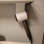 Under shelf holder with a Dyson Supersonic hair dryer hanging beneath a bathroom shelf, view 2