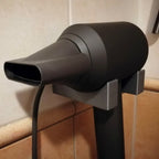 Bathroom wall mount holder for Dyson Supersonic hair dryer with cord routed down the wall