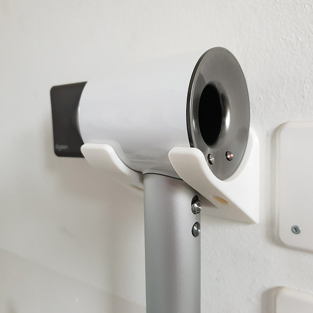 Minimalist two-arm wall cradle holding a Dyson Supersonic hair dryer horizontally, view 3