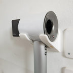 Minimalist two-arm wall cradle holding a Dyson Supersonic hair dryer horizontally, view 3