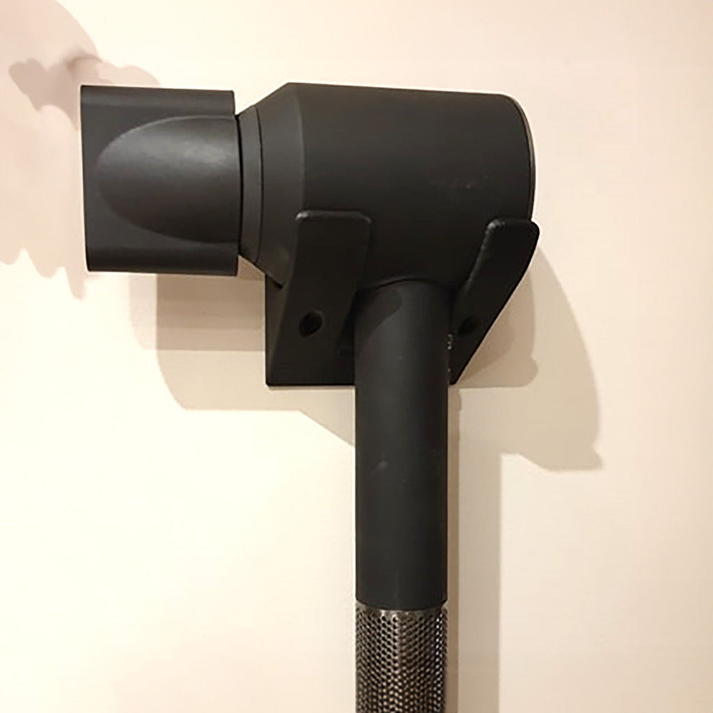 Minimalist two-arm wall cradle holding a Dyson Supersonic hair dryer horizontally, view 4