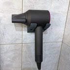 Minimalist two-arm wall cradle holding a Dyson Supersonic hair dryer horizontally