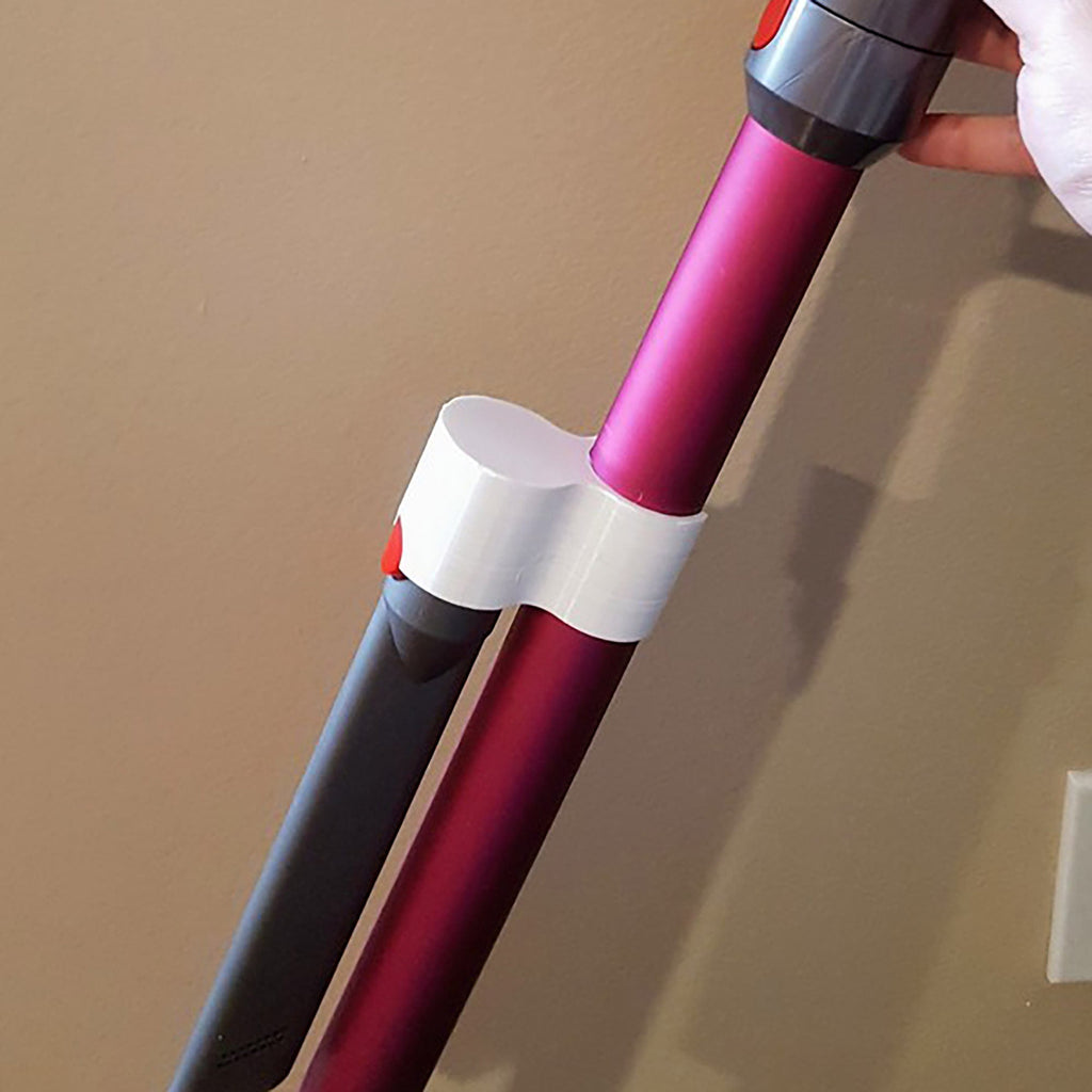 Storage clip holding a Dyson V7 or V8 stick vacuum wand upright on a broom handle, view 2