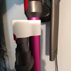 Storage clip holding a Dyson V7 or V8 stick vacuum wand upright on a broom handle, view 3
