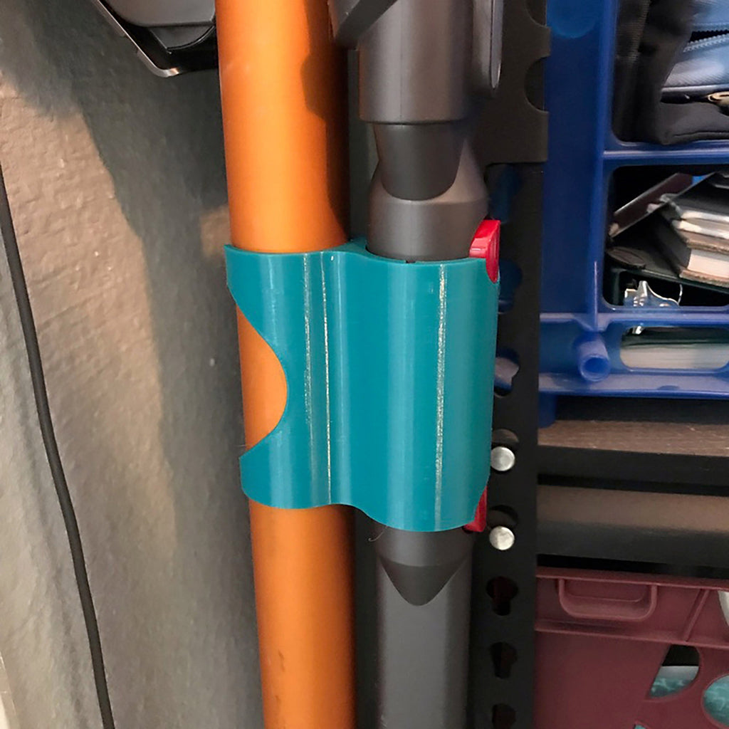 Storage clip holding a Dyson V7 or V8 stick vacuum wand upright on a broom handle, view 4